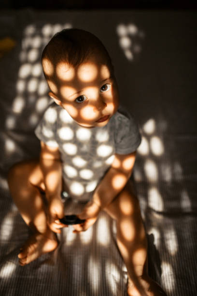 istock Sunlight reflection on cute baby in bedroom 1327963346