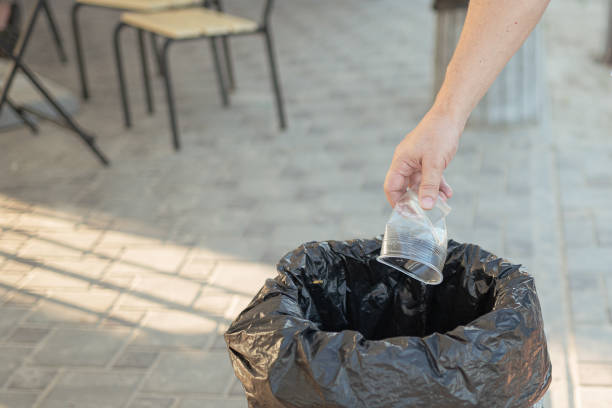 istock A man throws an empty plastic cup into a trash can at the beach area 1327963432