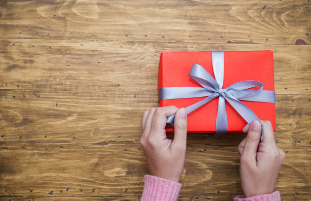 istock Woman hands wrapping gift box top view, celebration holiday christmas unwrap open box concept. 1327965247