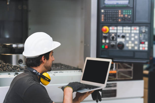 istock Engineer using laptop computer operating control CNC Machinery at factory Industrial 1327965630