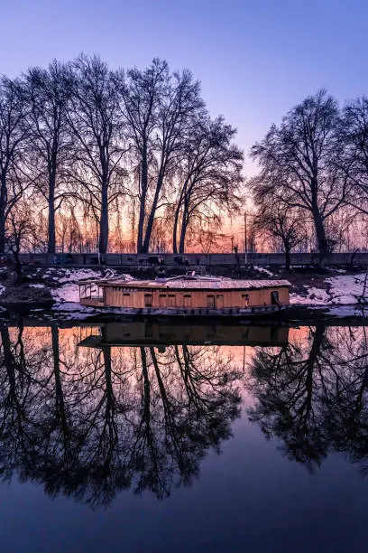 A beautiful view created by reflection of houseboats and trees on the bank of river Jhelum, Jammu and Kashmir, India