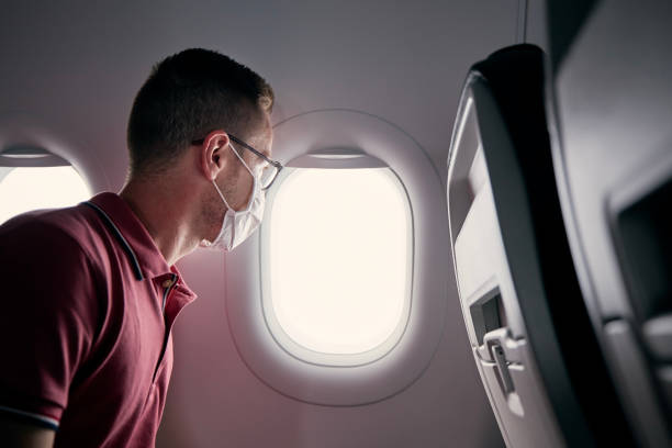 istock Passenger with protective face mask in airplane