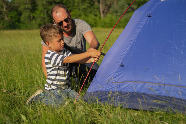 istock father is teaching his son to pitch a tent 1327972838