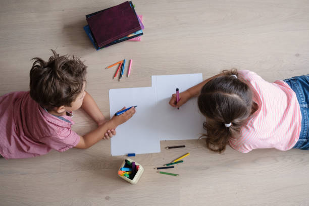 istock Cute girl and boy studying at home, make homework 1327973728