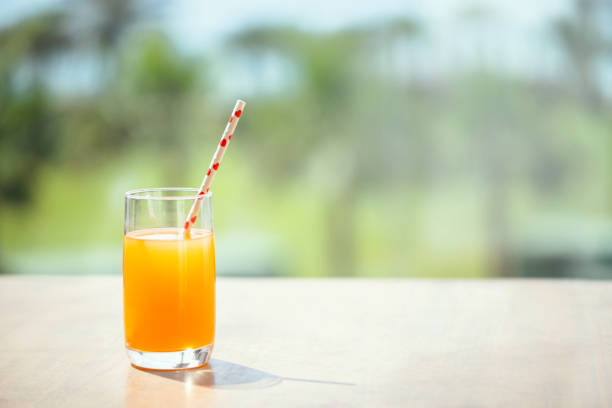 Orange juice on the table in the palm tree forest. Summer vocation. Concept