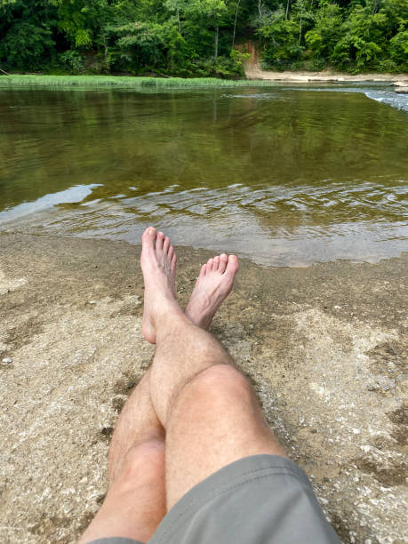 istock Person relaxing on concrete slab near river 1327977185