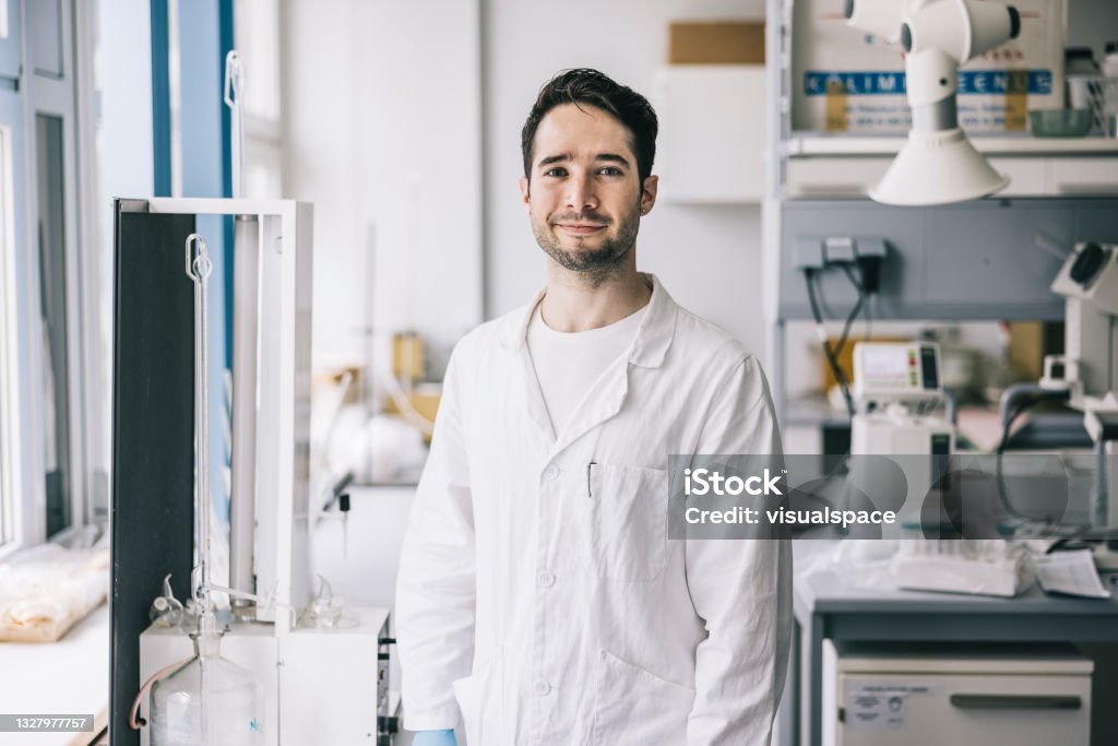 Positive scientist in workplace Portrait of handsome young scientist in laboratory CRISPR Stock Photo