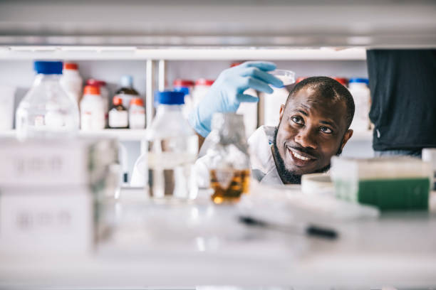 scienziato positivo che fa una nuova scoperta - laboratory scientist african ethnicity science foto e immagini stock