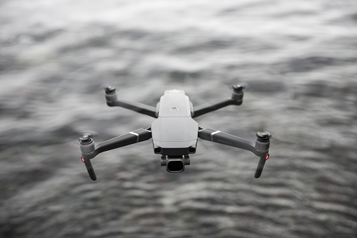 Cornwall, UK - June 29, 2021.  A DJI Mavic Pro 2 unmanned drone flying above water and facing the camera with copy space