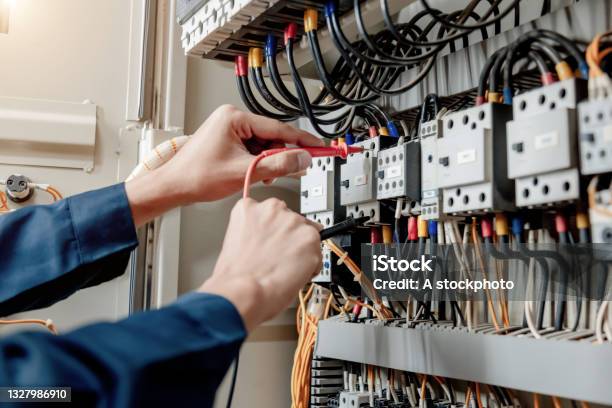 Electrician Engineer Uses A Multimeter To Test The Electrical Installation And Power Line Current Stock Photo - Download Image Now
