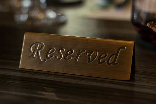 Reserved plate sign on wooden table at restaurant
