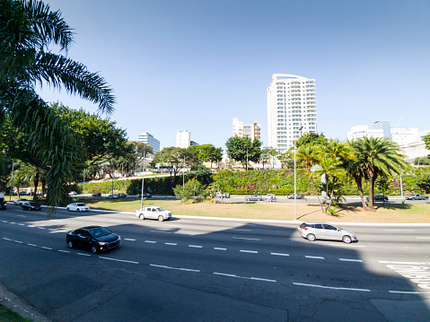 Photo taken over 23 de maio Ave, Sao Paulo city, Brazil. Traffic flowing.\nMany plants on the wall beside the avenue.