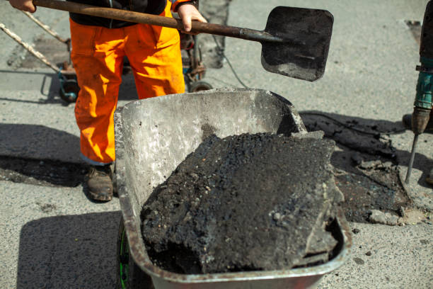 istock Construction waste trolley. Puts the asphalt into the cart with a shovel. 1327989262