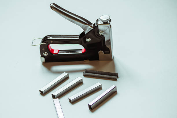 istock Furniture stapler next to staples on a white background. 1327991899