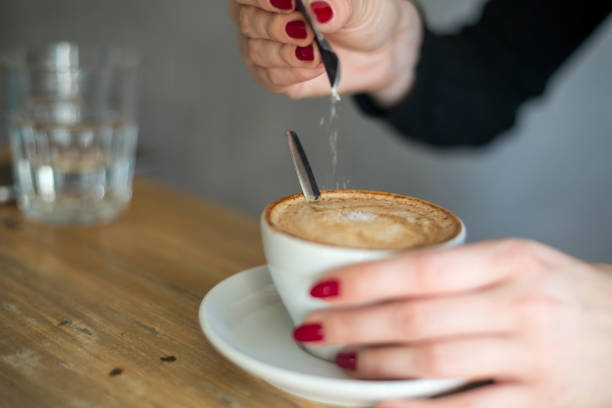 istock drink with woman hand adding sugar on a coffee 1327992841
