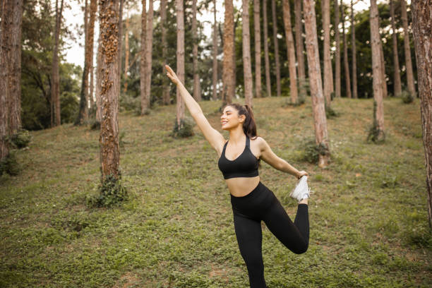 istock Happy woman doing warm up exercise before training in forest 1327993185