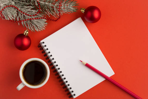 istock Open notepad, black coffee in the white cup and Christmas compositionon the  red  background 1327994542