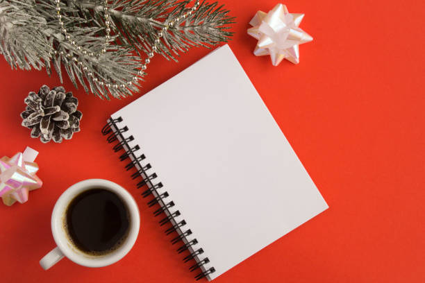 istock Open notepad, black coffee in the white cup and Christmas composition on the  red  background 1327994594
