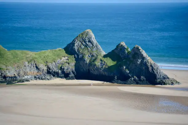 A popular tourist spot in the South Wales coastline, Three Cliffs Bay is a spectacular sandy beach with a rocky outcrop near the waters edge. A must visit on the Gower Peninsula, Swansea.