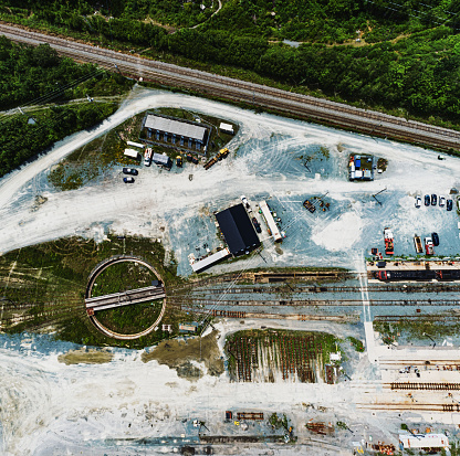 A wide angle drone view of a railyard with disused turntable.