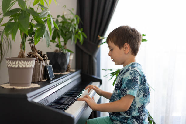 istock Child practices piano inside his house 1328007170