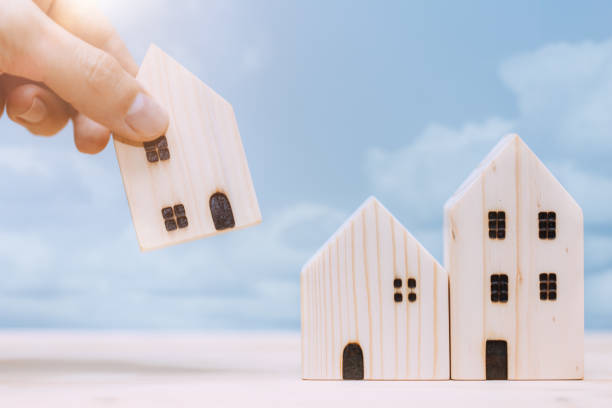 istock Hand placed or move home model for relocate or moving house concept. 1328008621