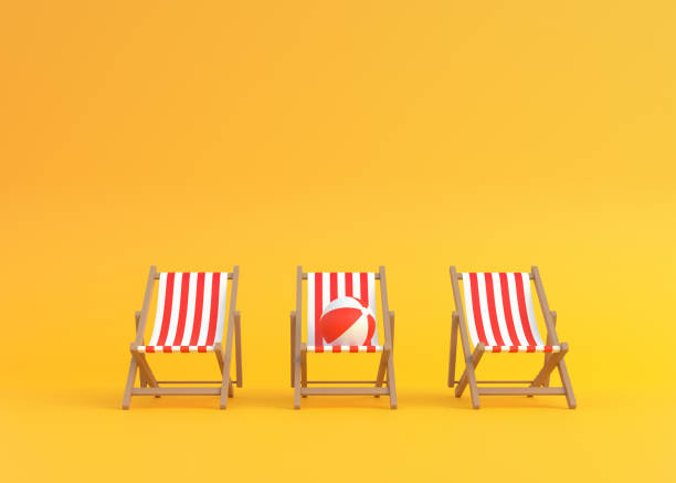 istock Striped deck chairs and beach ball on a yellow background 1328009576
