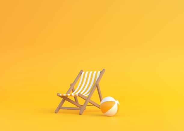 striped deck chair and beach ball on a yellow background - toldo objeto manufaturado imagens e fotografias de stock