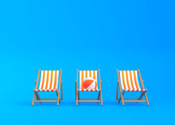 istock Striped deck chairs and beach ball on a blue background 1328009597