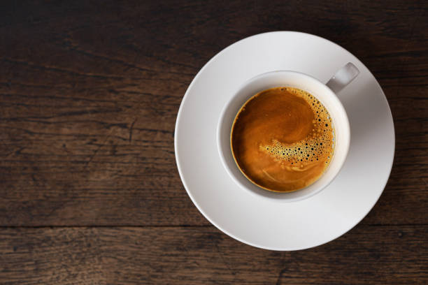 istock dark rost espresso coffee on white cup on old wooden table background with copy space. 1328009872