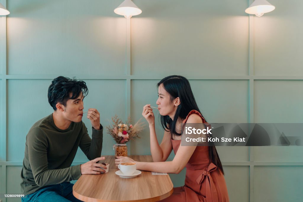 Young couple locking eyes in a cafe Couple - Relationship Stock Photo