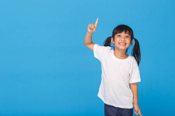 istock Good idea! Pretty girl pointing up while standing . Copy space 1328013661