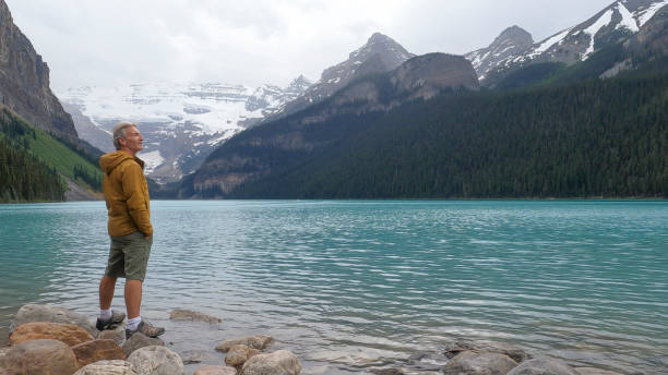 el excursionista se relaja cerca del hermoso lago louise por la mañana - lago louise lago fotografías e imágenes de stock