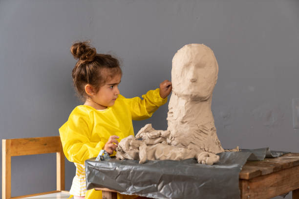 istock Elementary Preschooler Girl Making Clay Sculpture 1328021376