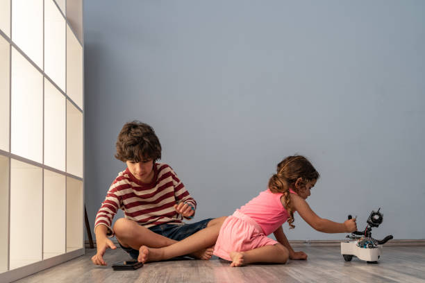 istock Brother And Sister Playing With Toy Robot 1328025621