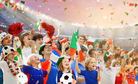 Italy football supporter on stadium. Italian fans on soccer pitch watching team play. Group of supporters with flag and national jersey cheering for Italia. Championship game. Forza Azzurri