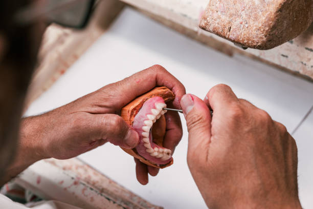 istock Dental technician fixing a dental prosthesis in a workshop 1328027786