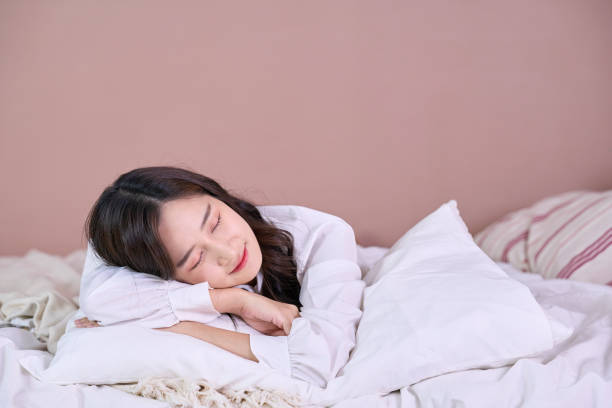 istock Asian woman relax on bed and smile 1328027878