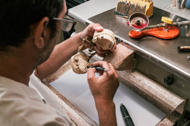 istock Dental technician fixing a dental prosthesis articulator 1328028513