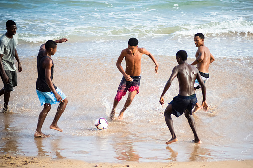 Salvador, Bahia Brazil - September 25, 2020: Young people playing soccer on Farol da Barra beach in full pandemic. Moment of liberated beaches to favor the local economy.