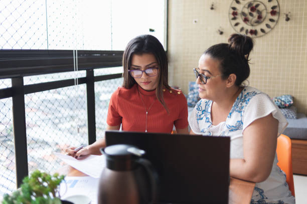 Mother and daughter doing finances together at home Mother and daughter doing finances together at home. They talk and handle some bills college student and parent stock pictures, royalty-free photos & images