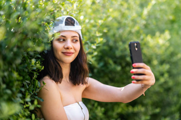 istock Young woman taking selfies with smart phone in nature 1328033448