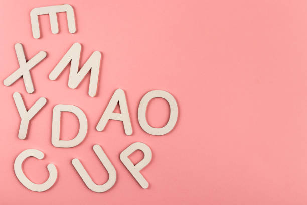 istock Wooden alphabet letters on pink paper background. 1328038120