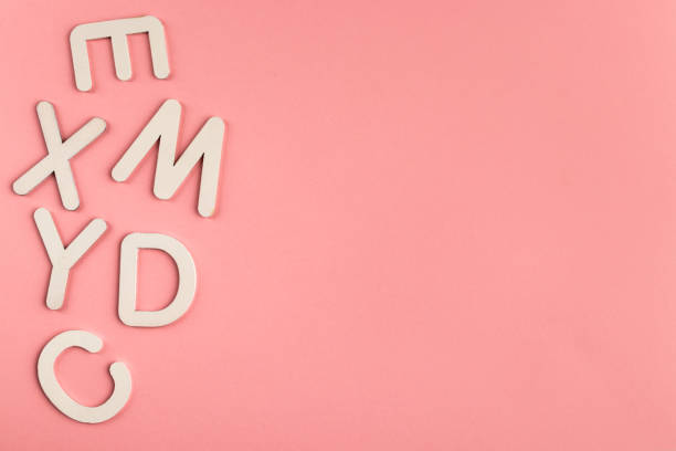 istock Wooden alphabet letters on pink paper background. 1328038122