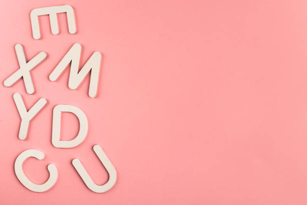 istock Wooden alphabet letters on pink paper background. 1328038124