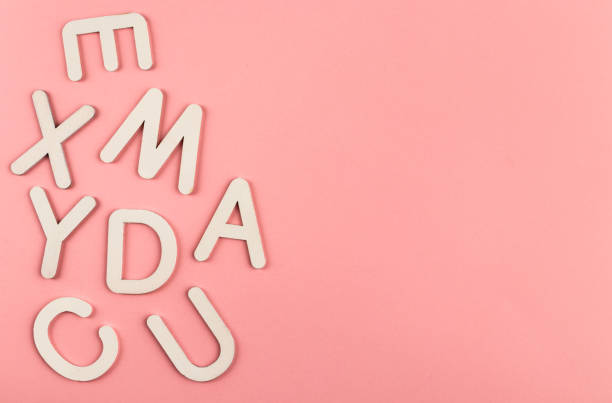 istock Wooden alphabet letters on pink paper background. 1328038127