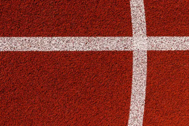 Basketball court lines. Top view to brown field rubber ground with white lines.