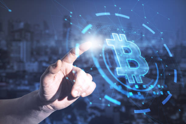istock Hand pointing at abstract glowing bitcoin interface on blurry night city background. Cryptocurrency concept. Double exposure. 1328041659