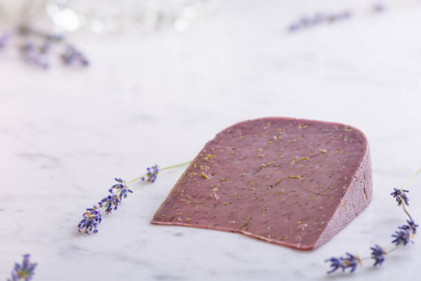 rebanada de queso de lavanda y flores de lavanda sobre mesa de mármol blanco - basiron fotografías e imágenes de stock