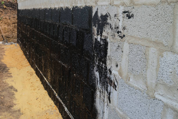 Protective waterproofing coating of walls in contact with the ground with bituminous mastic stock photo